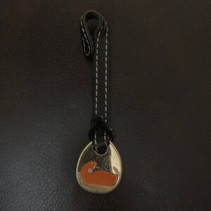Dooney & Burke orange duck replacement hangtag on black leather.